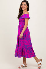 woman wearing a bright pink off-the-shoulder floral midi dress with a ruffled hem and white block-heel sandals