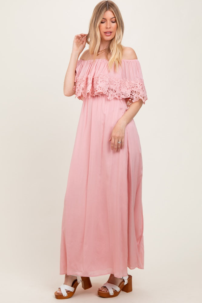 woman wearing a pink off-the-shoulder maxi dress with lace details and a flowy silhouette