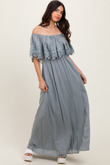 woman wearing a light gray off-the-shoulder maxi dress with lace detail