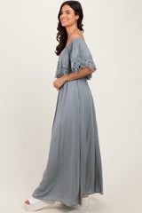 woman wearing a long gray off-shoulder maxi dress with lace details and flowing silhouette