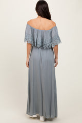 woman wearing a light gray off-the-shoulder maxi dress with lace details on the sleeves, shown from the back