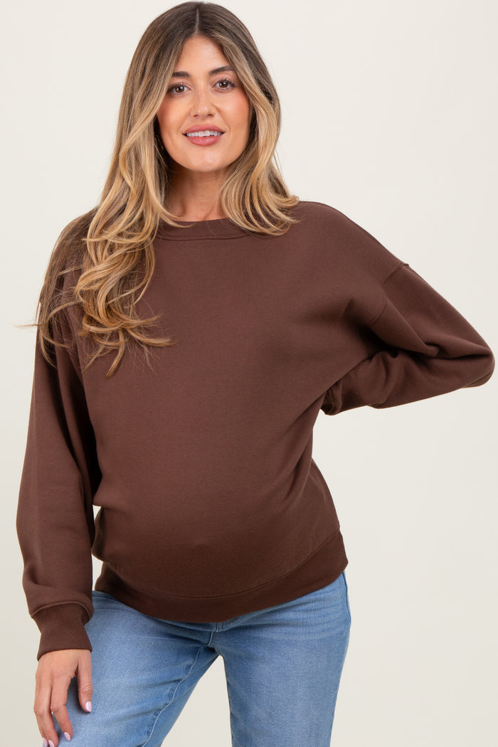 woman wearing a brown maternity sweatshirt with relaxed fit and long sleeves, showing her baby bump