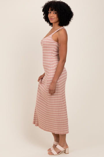 woman wearing a pink and white striped midi dress with thin straps and a flowy skirt, standing sideways