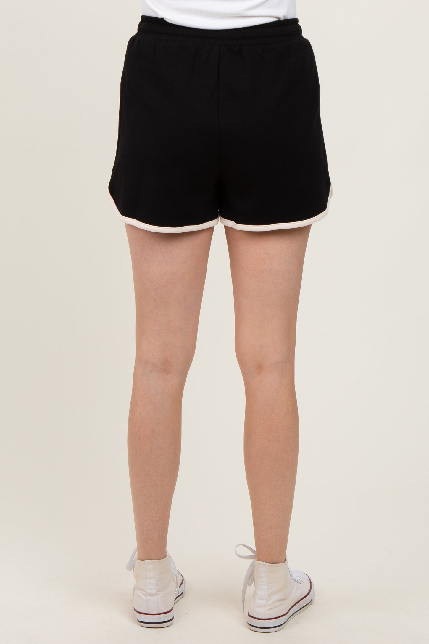 woman wearing black shorts with white trim, shown from the back