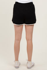 woman wearing black shorts with white trim, shown from the back