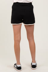 woman wearing black maternity shorts with white piping, viewed from the back