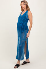 woman wearing a blue crochet maternity dress with a tie waist and side slits, showcasing her baby bump