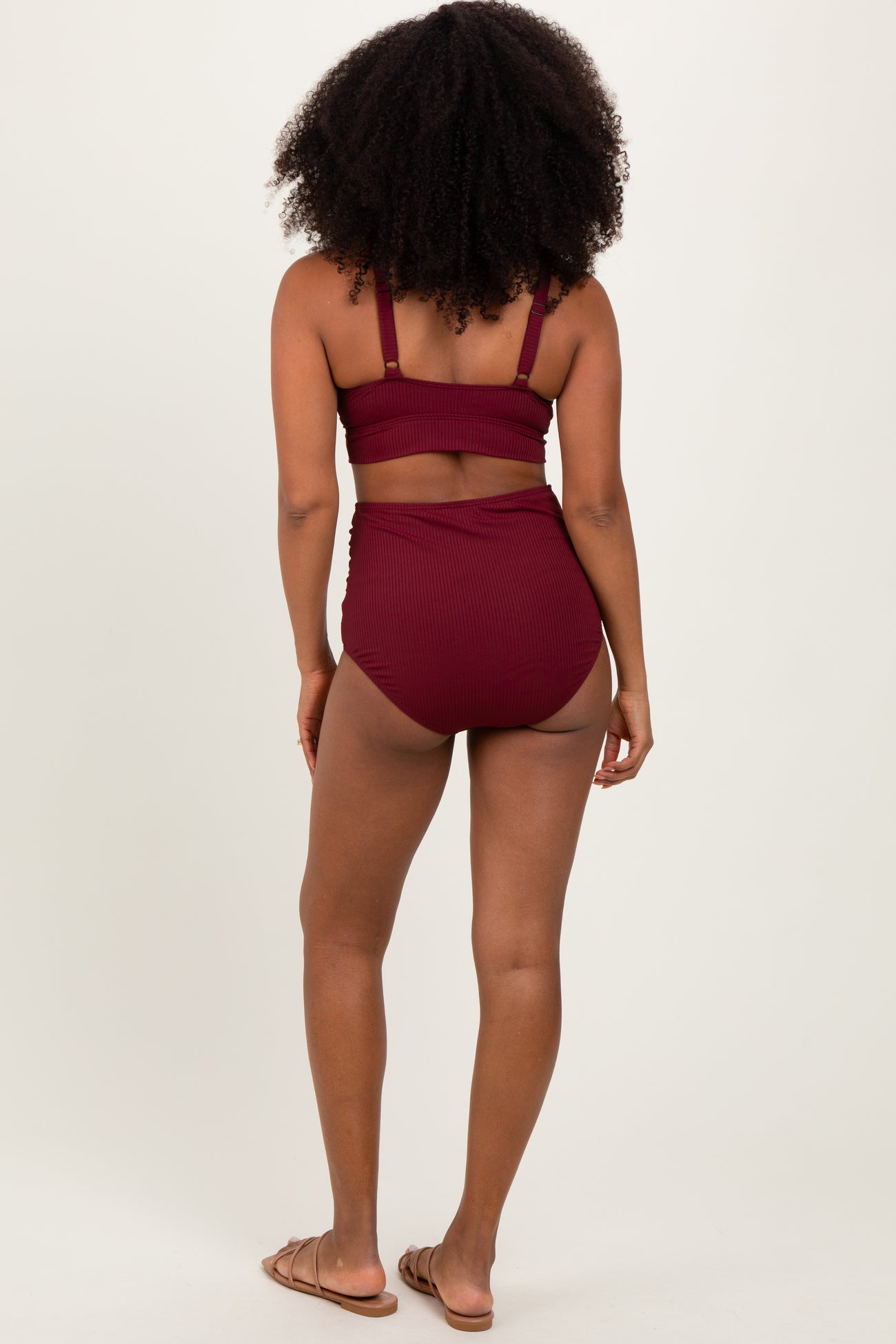woman wearing a burgundy ribbed bikini set with a high-waisted bottom, shown from the back