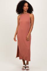woman wearing a dusty rose sleeveless maxi dress with side slit and styled with white heeled sandals