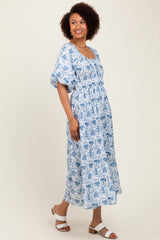 woman wearing a blue and white floral maxi dress with short puff sleeves and a cinched waist