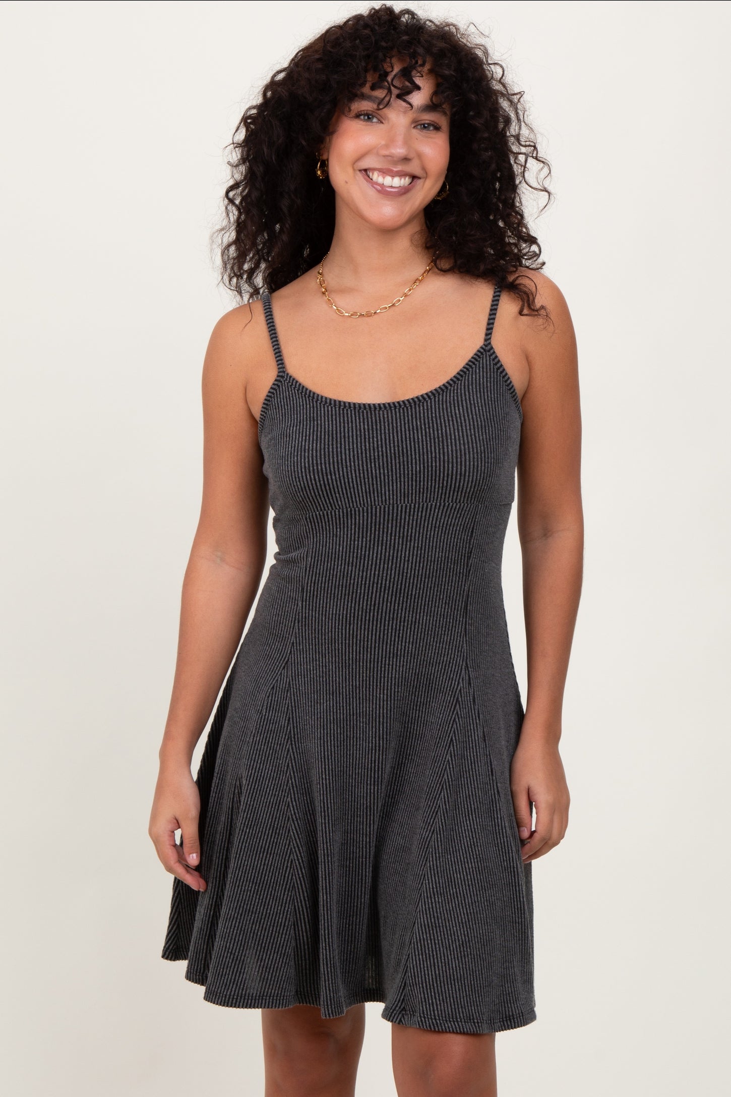 woman wearing a black and white striped sleeveless fit-and-flare dress with a scoop neckline