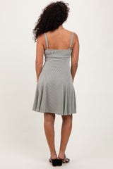 woman wearing a light grey ribbed sundress with a flared skirt and adjustable straps, shown from the back