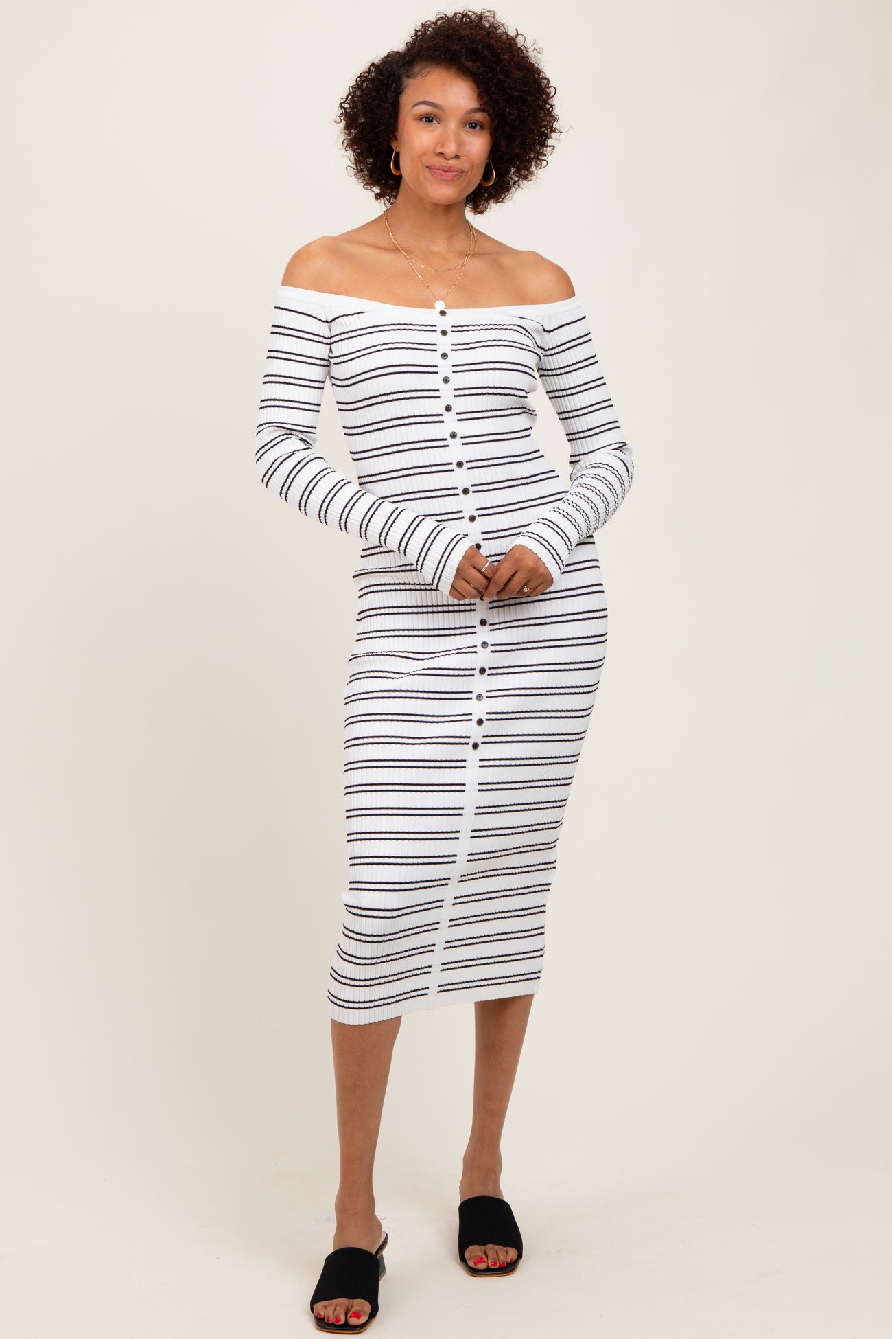 woman wearing a white and navy striped off-the-shoulder midi dress with long sleeves and button details