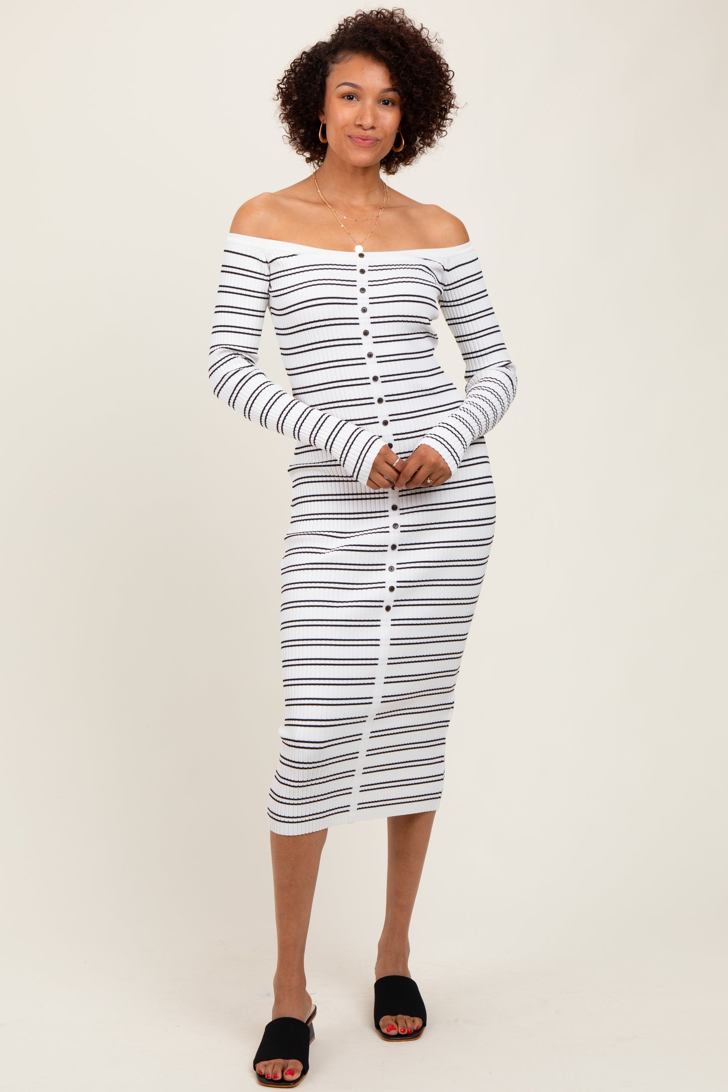 woman wearing a white and navy striped off-the-shoulder midi dress with long sleeves and button details