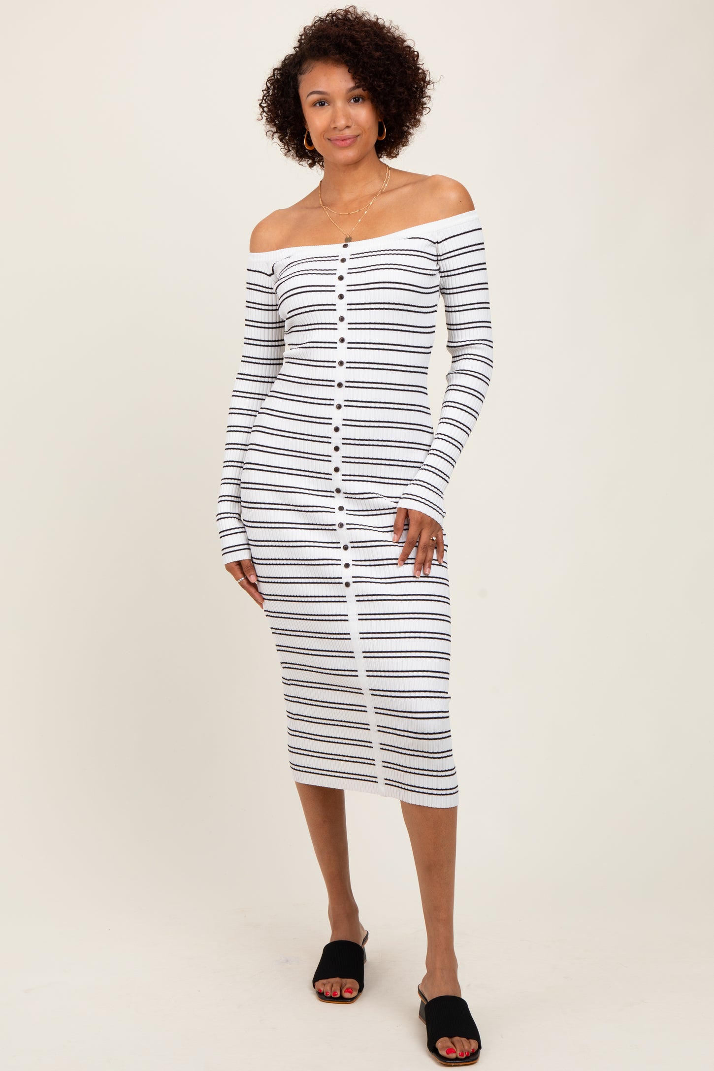 woman wearing a white and navy striped off-the-shoulder midi dress with button detailing and long sleeves