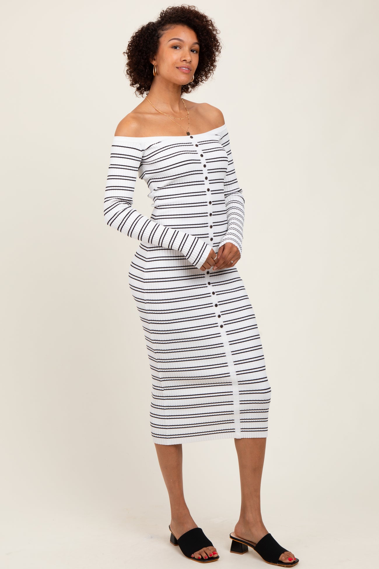 woman wearing a white and navy striped off-the-shoulder midi dress with long sleeves and button detailing