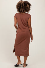 woman wearing a brown maternity maxi dress with short sleeves and a side slit, showing no visible baby bump