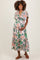 woman wearing a floral maternity maxi dress with short sleeves and a flowing skirt, holding her baby bump