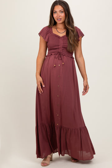 woman wearing a burgundy maternity maxi dress with smocked bodice, ruffle sleeves, and button details