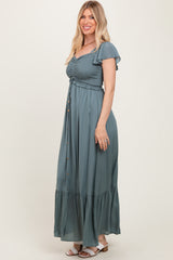 woman wearing a teal maxi dress with short ruffle sleeves and a button-up front detail