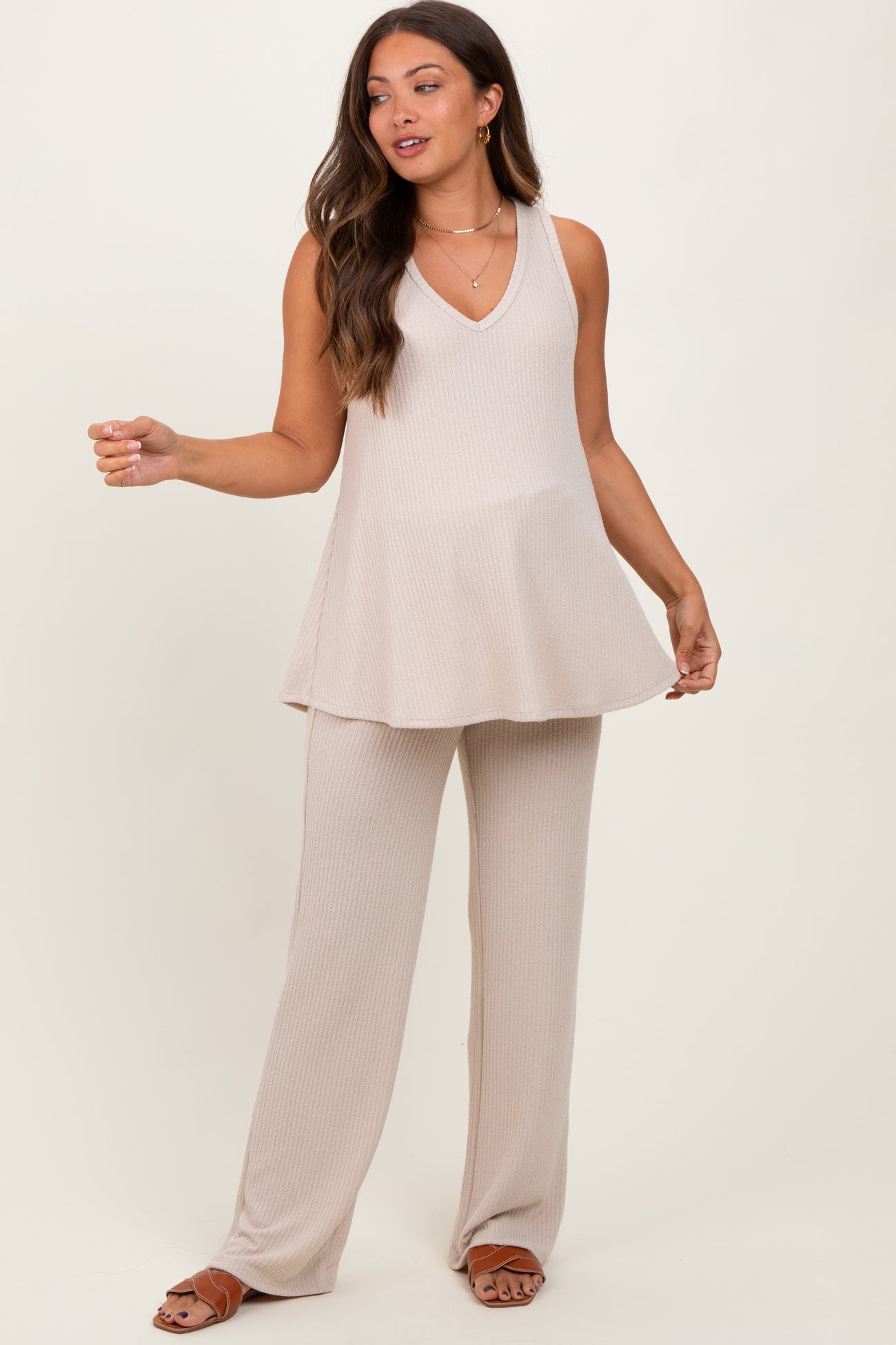 woman wearing a beige maternity tank top and matching wide-leg pants, showcasing a flowy silhouette