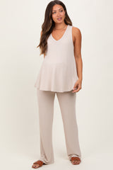 woman wearing a beige maternity top and matching pants, gently flowing with a visible baby bump
