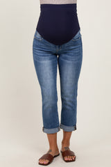 woman wearing dark blue maternity jeans with a high waistband and rolled cuffs