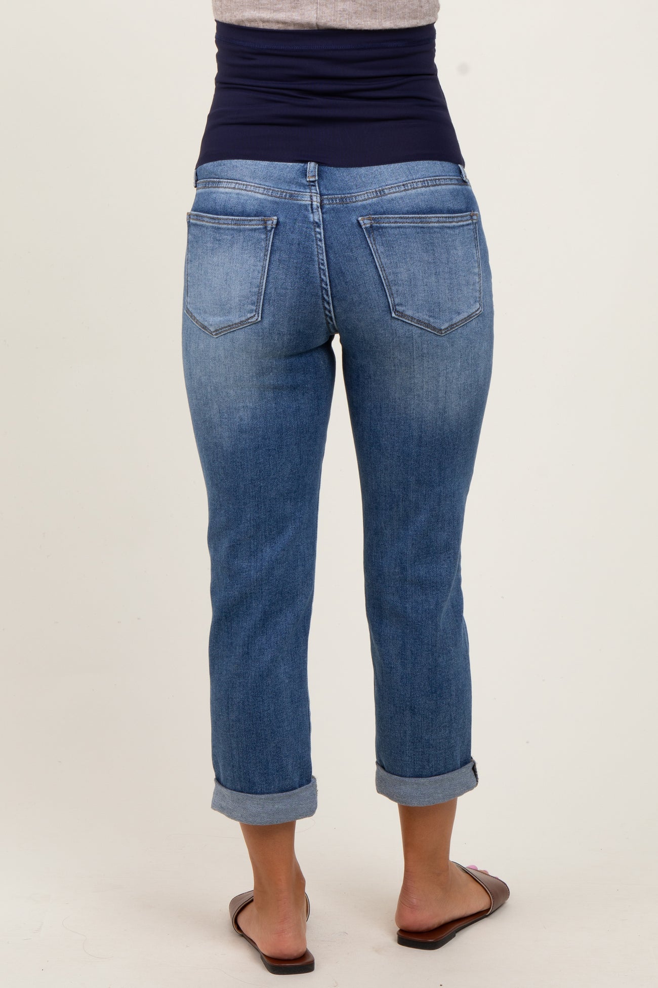 woman wearing a pair of cuffed light blue maternity jeans, viewed from the back