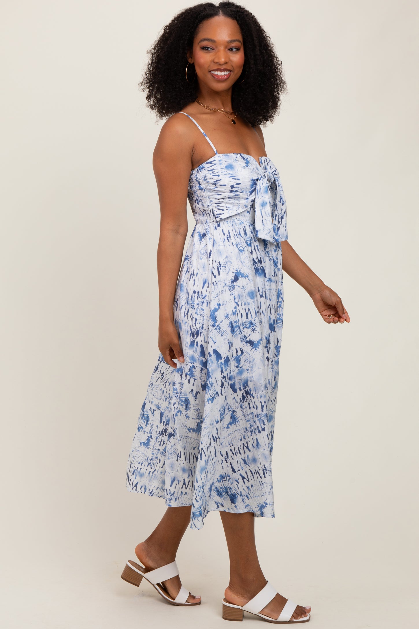 woman wearing a blue and white tie-front maxi dress with spaghetti straps and a flowy silhouette