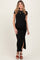 woman wearing a black maternity dress with a tie detail and side slit, showcasing her baby bump