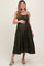 woman wearing a dark green midi maternity dress with a tie waist, holding her baby bump