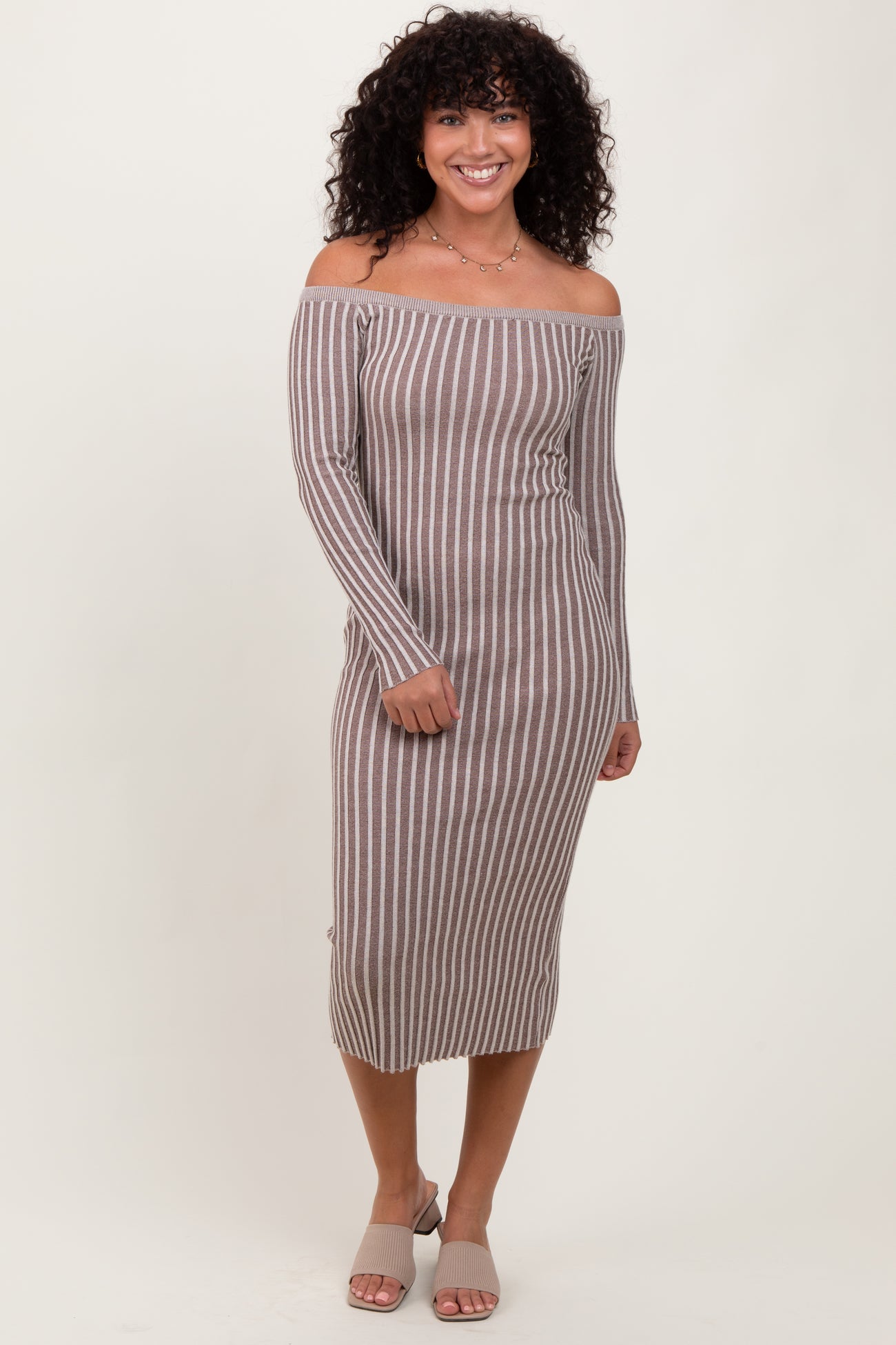 woman wearing a brown and white striped off-the-shoulder midi dress with long sleeves and side button details
