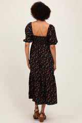 woman wearing a black floral maxi dress with puff sleeves and a smocked back