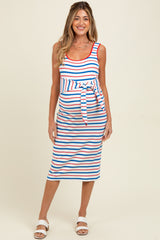 woman wearing a striped maternity dress with a tie waist, featuring red, blue, and white stripes and a visible baby bump