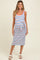 woman wearing a striped maternity dress with a tie waist, featuring red, blue, and white stripes and a visible baby bump