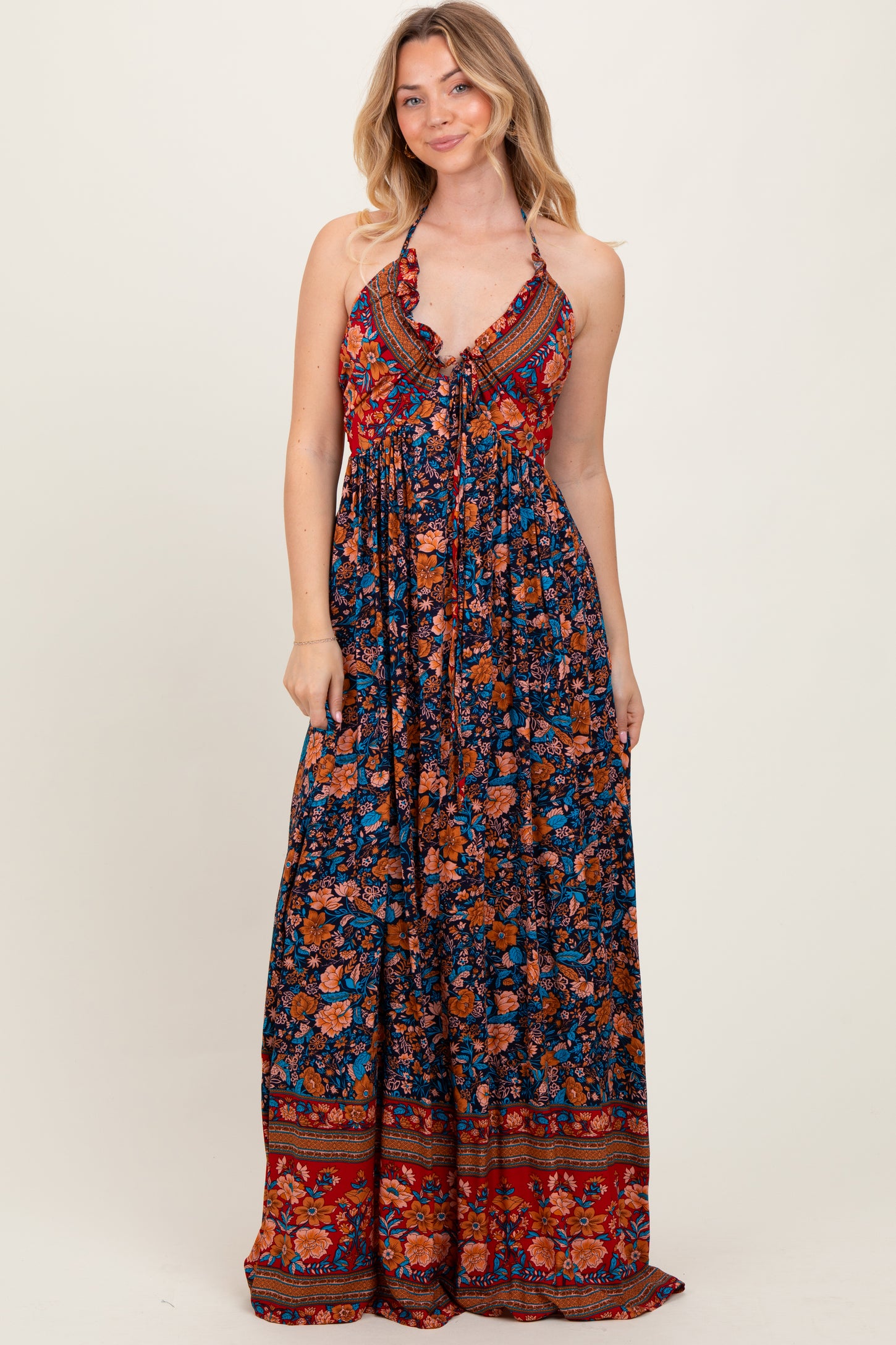 woman wearing a blue floral maxi dress with a halter neckline and ruffled details