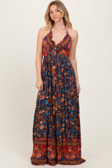 woman wearing a blue floral maxi dress with a halter neckline and ruffled details