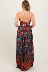 woman wearing a floral print strapless maxi dress with a tie back, featuring vibrant colors and intricate patterns
