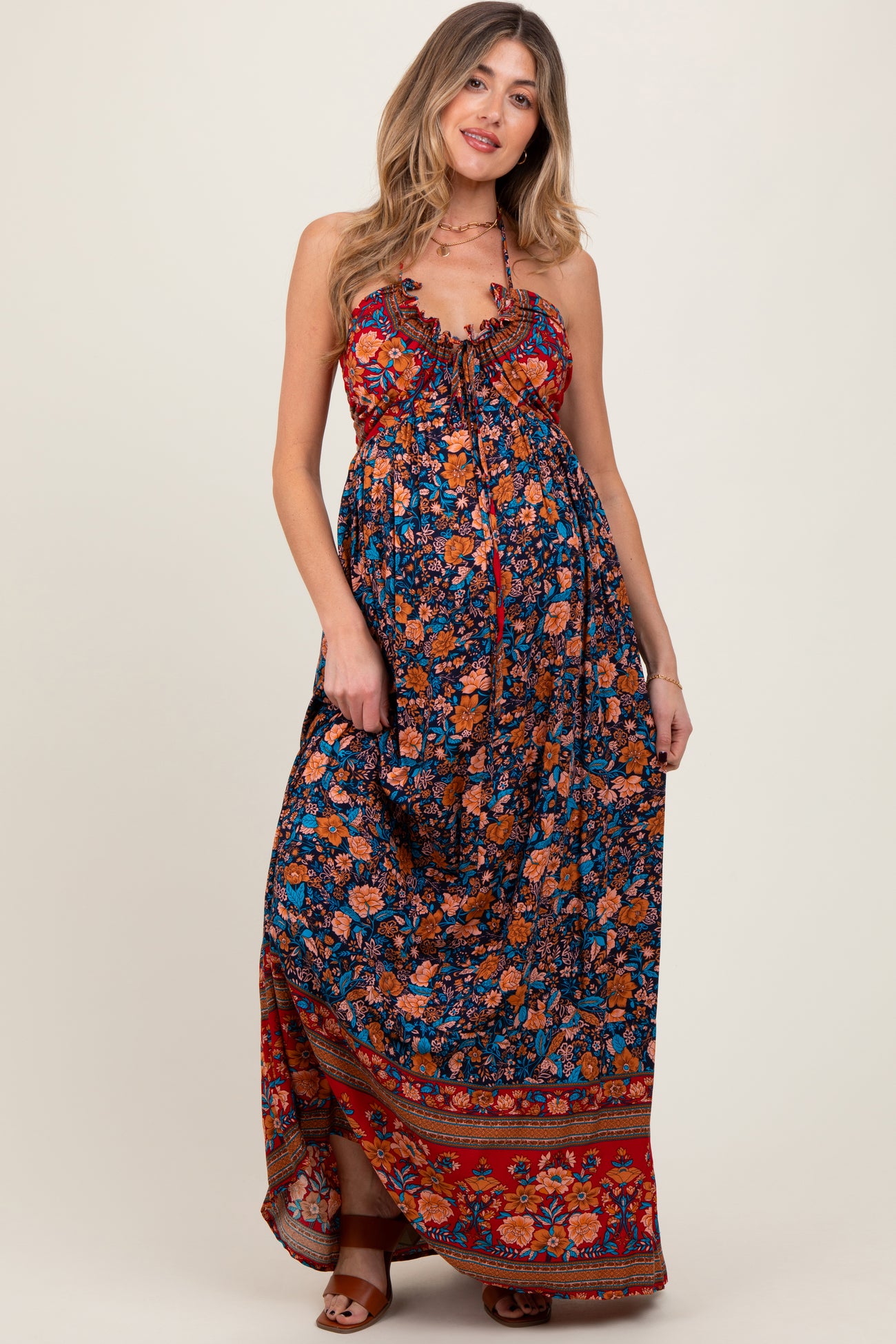 woman wearing a colorful floral print maternity maxi dress with adjustable straps and a flowing silhouette