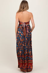 woman wearing a floral strapless maternity maxi dress with a tie back detail and flowing skirt