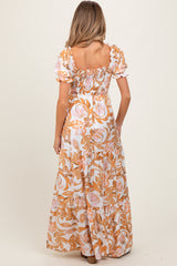 woman wearing a floral print maternity maxi dress with puff sleeves, seen from the back