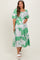woman wearing a green floral maternity dress with puffed sleeves and a baby bump visible