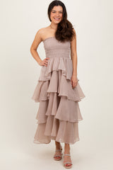 woman wearing a strapless nude tiered maxi dress with a smocked bodice and wavy ruffles