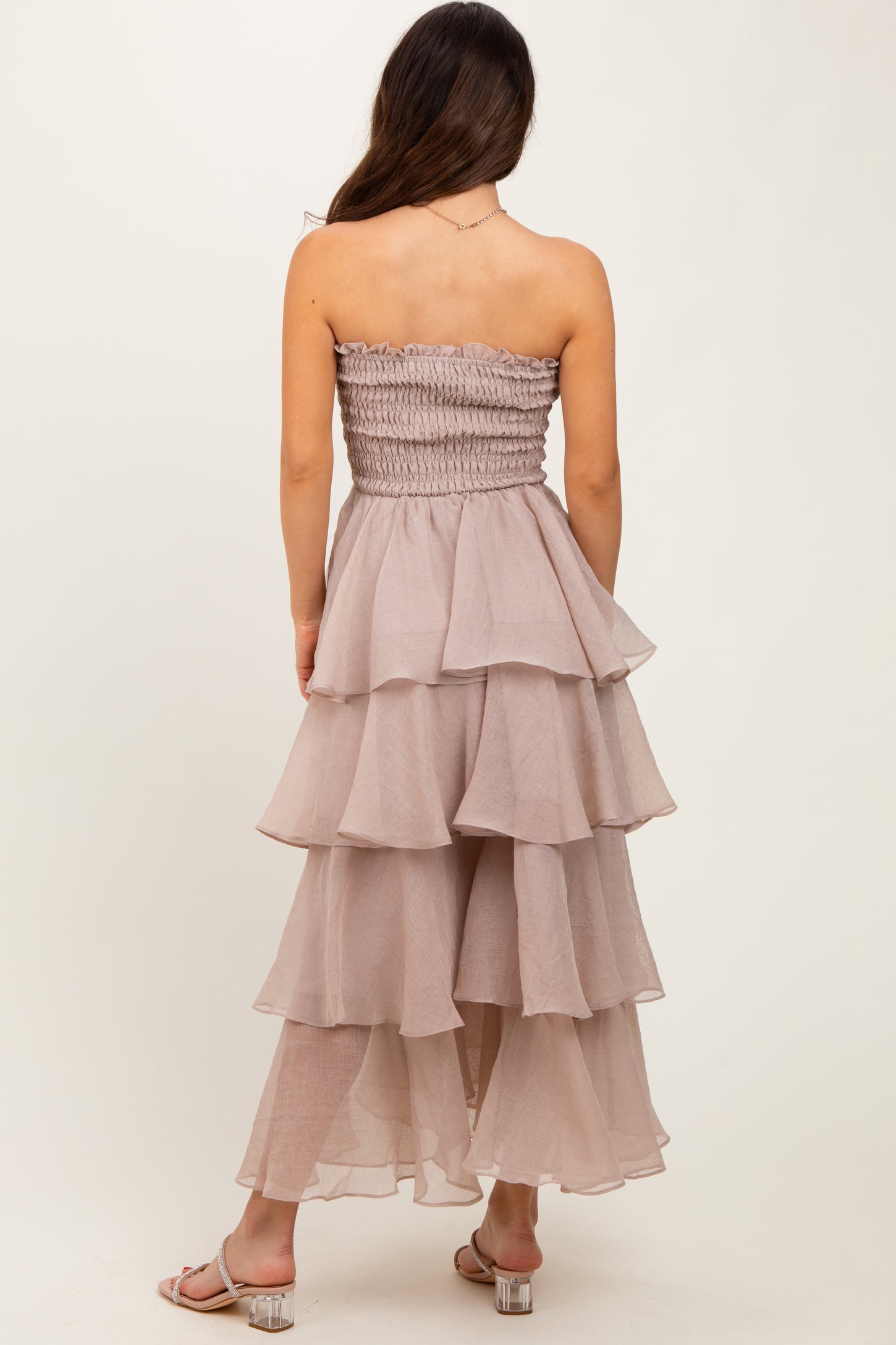woman wearing a tiered mauve strapless dress with a smocked bodice and ruffled layers