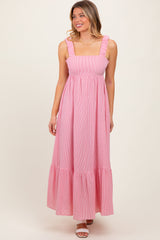 woman wearing a pink and white striped maxi dress with ruffled straps and a tiered skirt