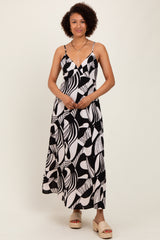 woman wearing a black and white abstract print maxi dress with spaghetti straps and a V-neckline