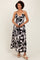 woman wearing a black and white abstract print maxi dress with spaghetti straps and a V-neckline