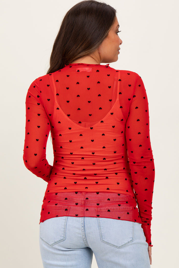 woman wearing a red sheer maternity top with black heart polka dots and long sleeves, seen from the back