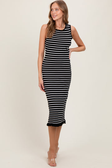 woman wearing a black and white striped sleeveless midi dress with ruffled hem and a fitted silhouette