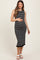 woman wearing a black and white striped maternity dress with a fitted silhouette and ruffle hem, gently holding her baby bump